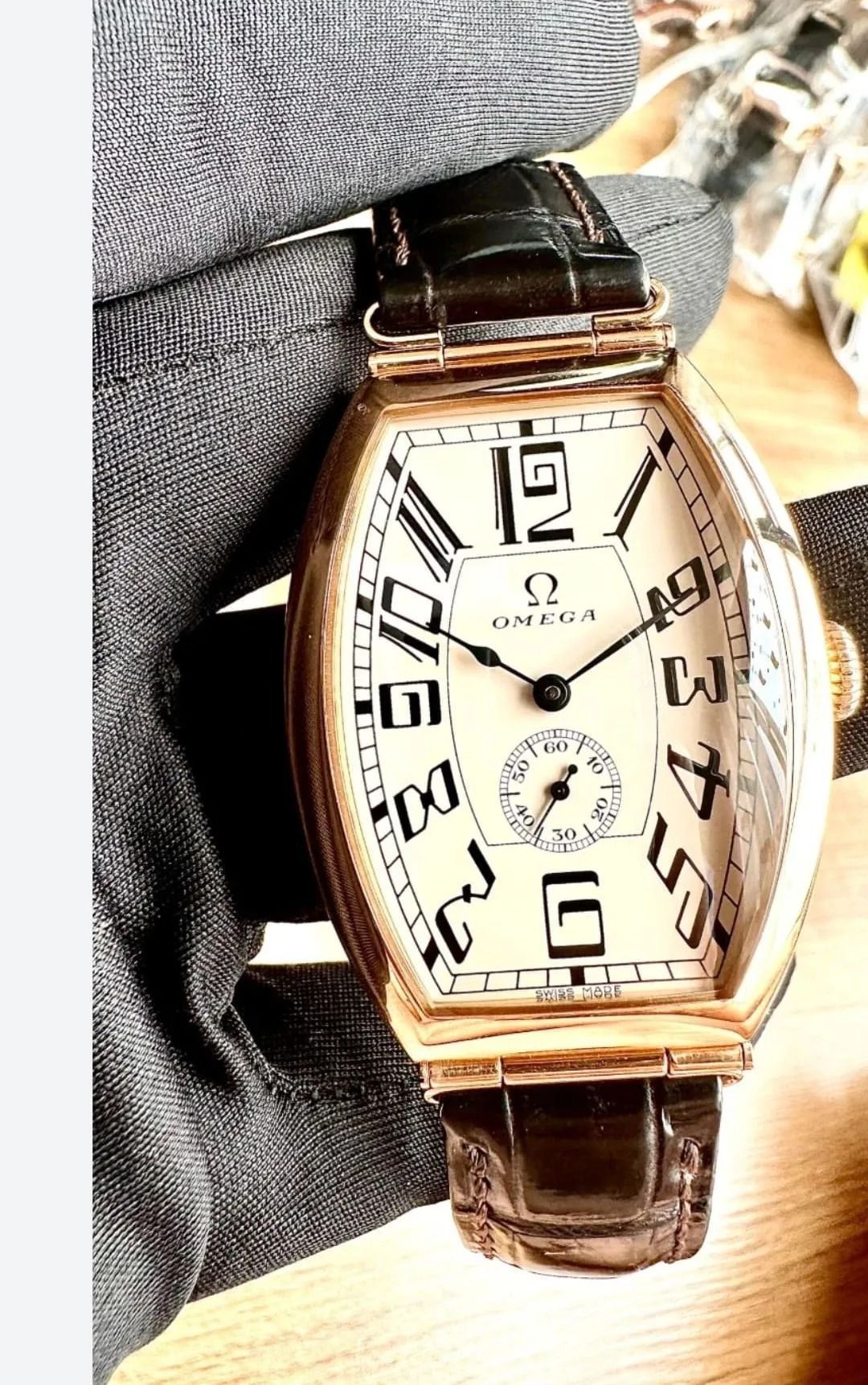 Una persona sostiene un reloj que dice omega.