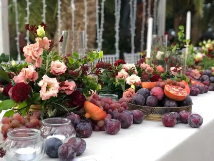 Mesa redonda para evento formal con mantel blanco, manteles individuales tejidos y cristalería color ámbar.