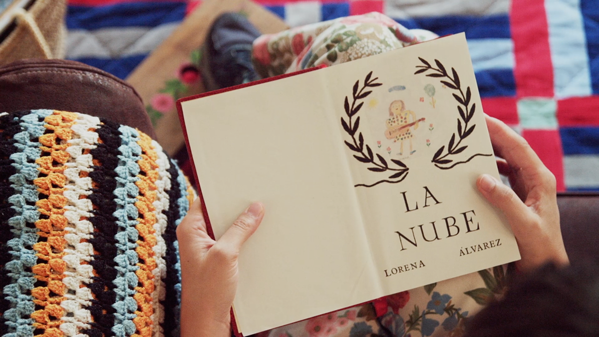 Persona sosteniendo un libro abierto titulado 