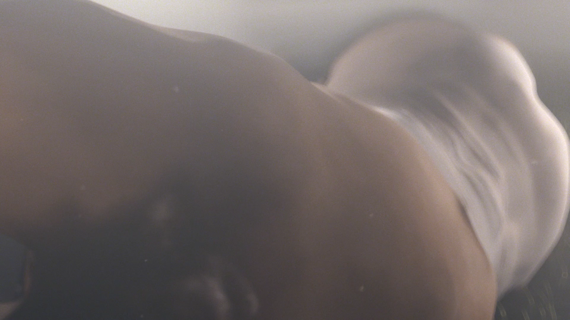 Persona en ropa interior blanca, inclinada. Primer plano desde abajo.