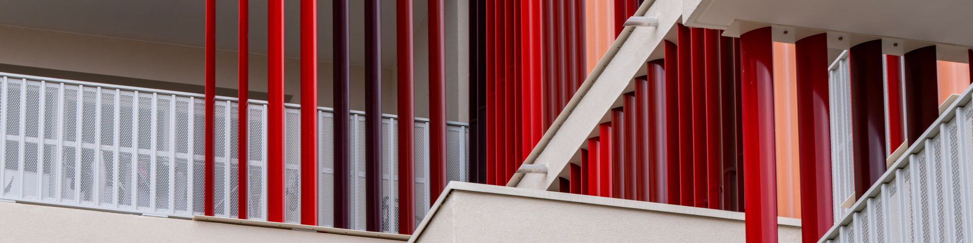 Barres verticales rouges et blanches sur un bâtiment. Les barres rouges alternent avec les barres blanches.