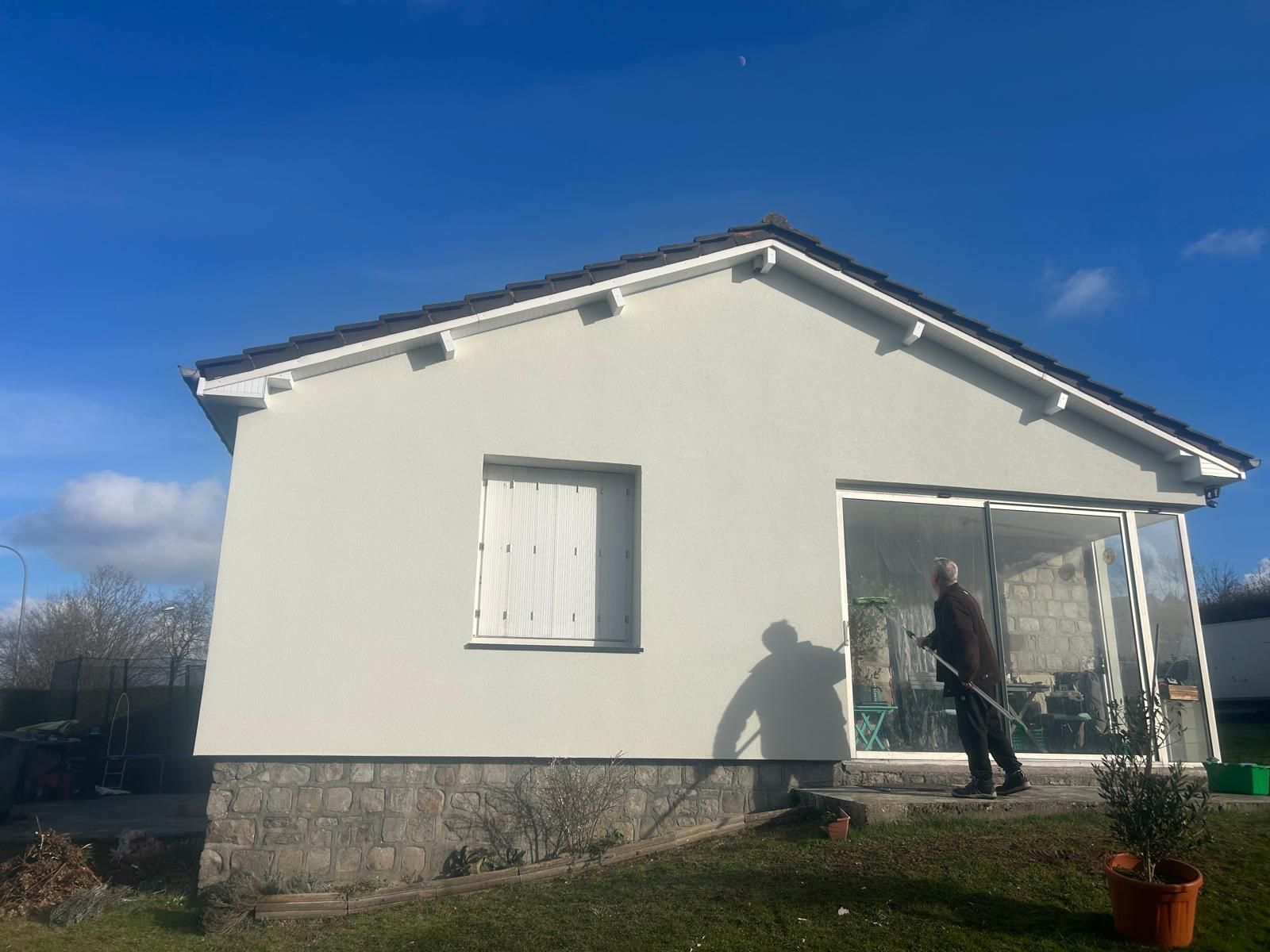 Gros plan sur un façadier qui applique un traitement hydrofuge.