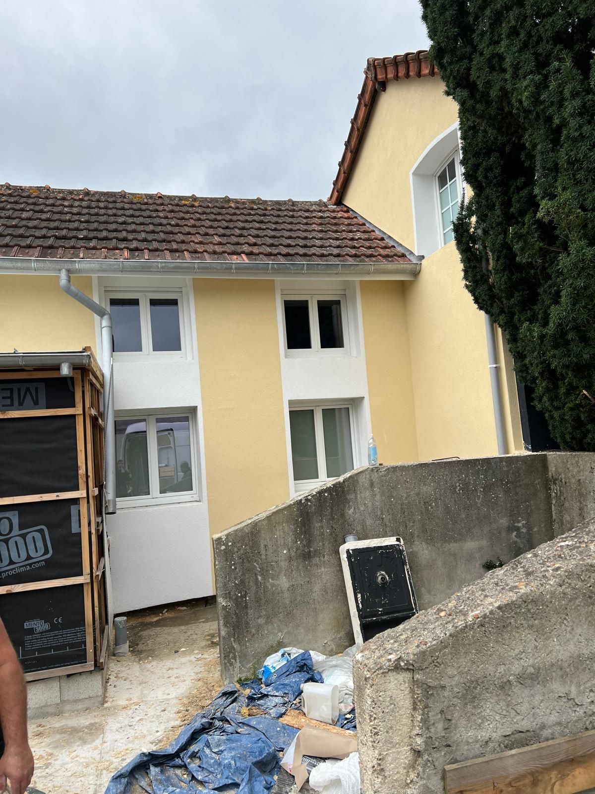 Vue de profil d'une façade en train d'être isolée.