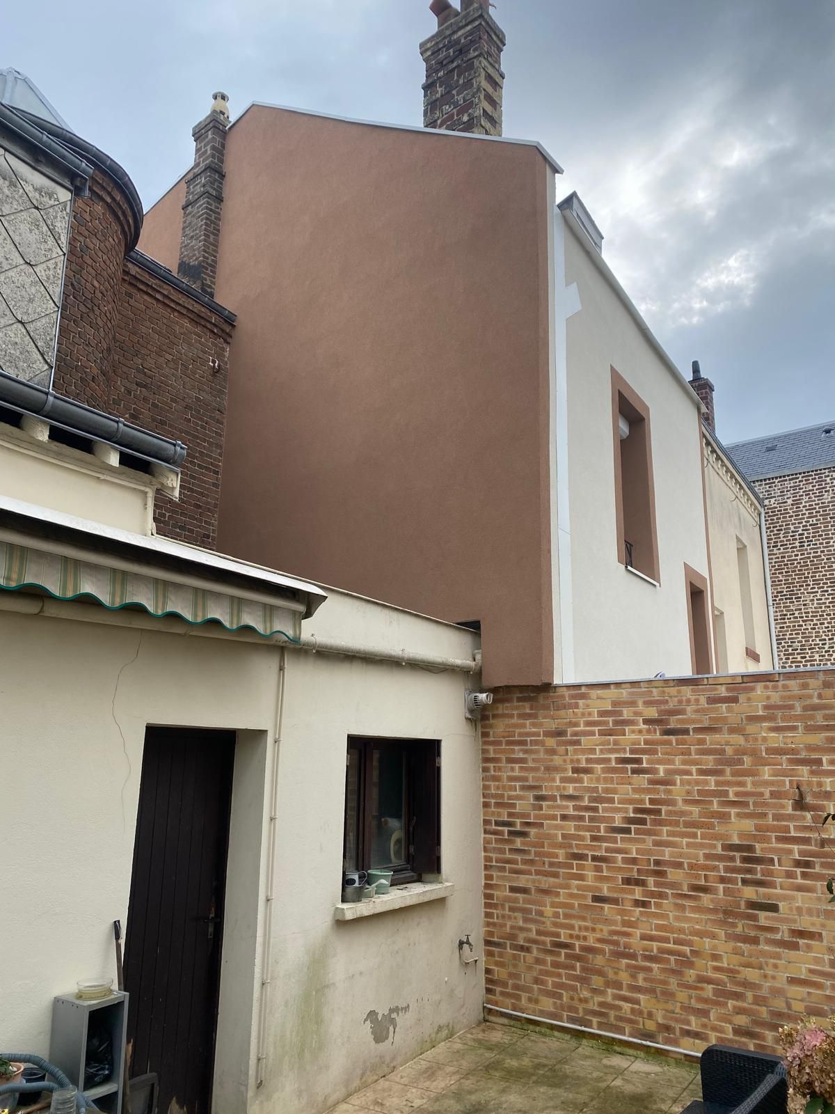 Maison avec une façade neuve et un bardage en bois.