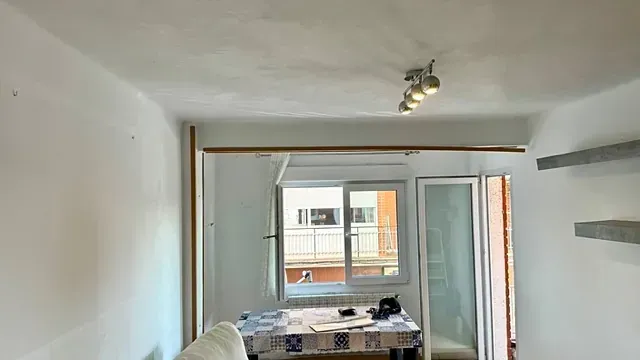 Una sala de estar con sofá, mesa y ventana.