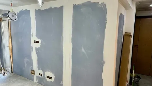 Una habitación con una pared que está siendo pintada.