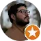 Un hombre con barba y gafas está en un círculo con una estrella naranja.