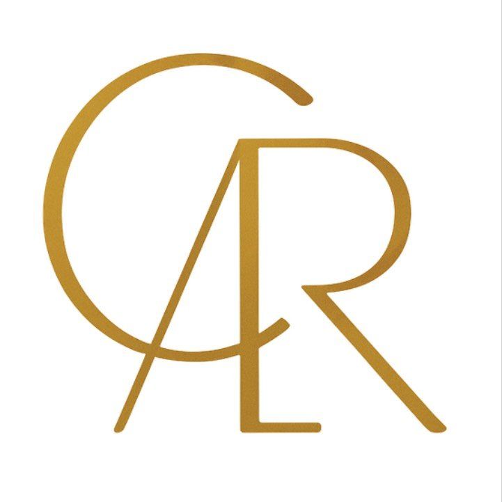 Monograma dorado de las letras “C”, “A” y “R”, entrelazadas.