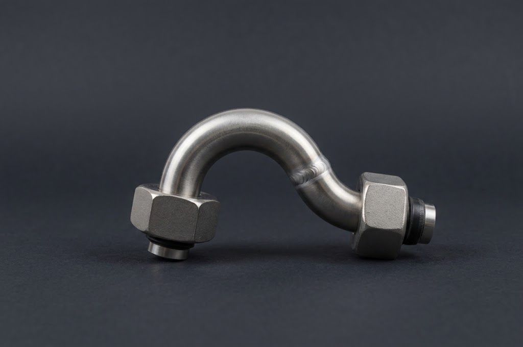 Metallene Fahrradständerskulptur auf einer Rasenfläche in der Nähe eines Gebäudes