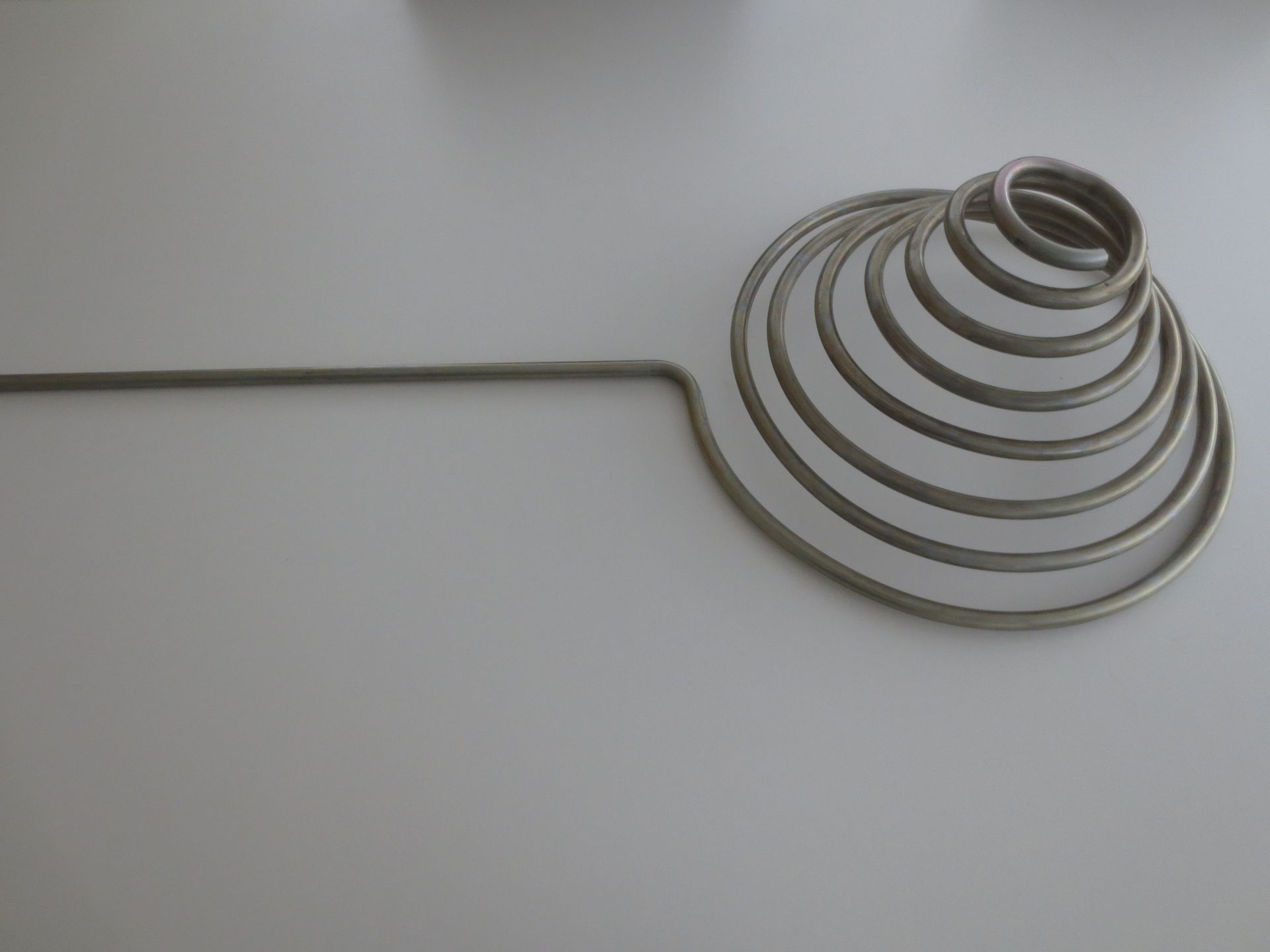Verschiedene Metallrohrbögen und -rohre in Silber, Weiss und Kupfer auf dunklem Hintergrund
