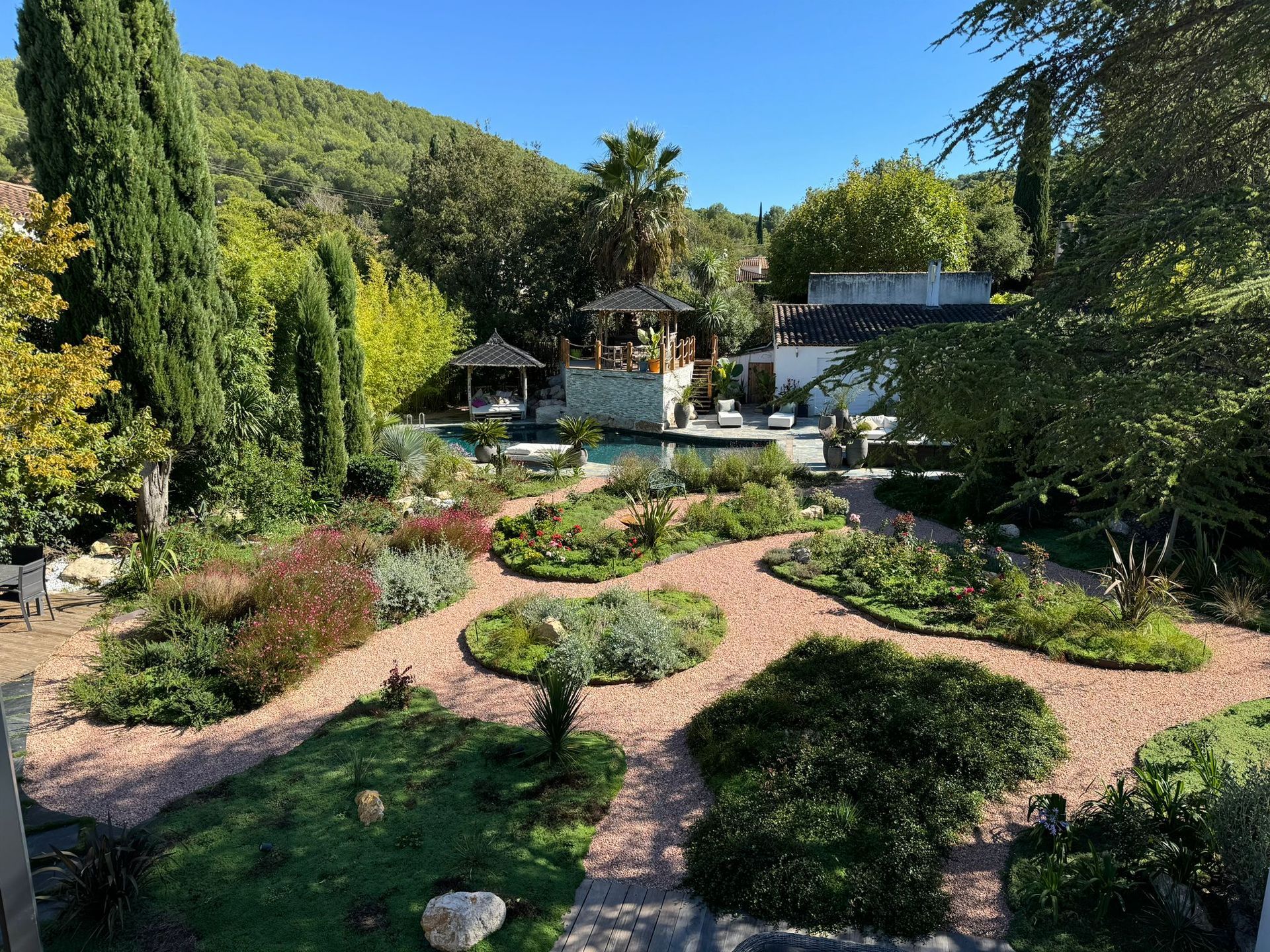 Une paisible terrasse à l'arrière d'une maison avec piscine, pelouse verdoyante,.