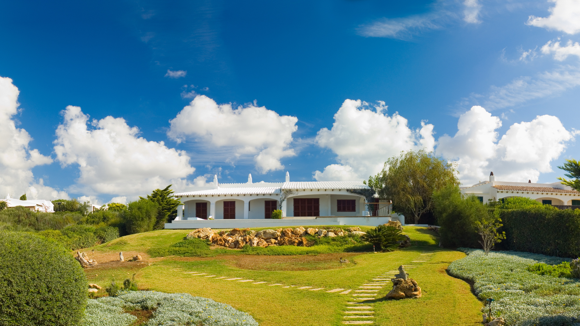 Une paisible terrasse à l'arrière d'une maison avec piscine, pelouse verdoyante,.