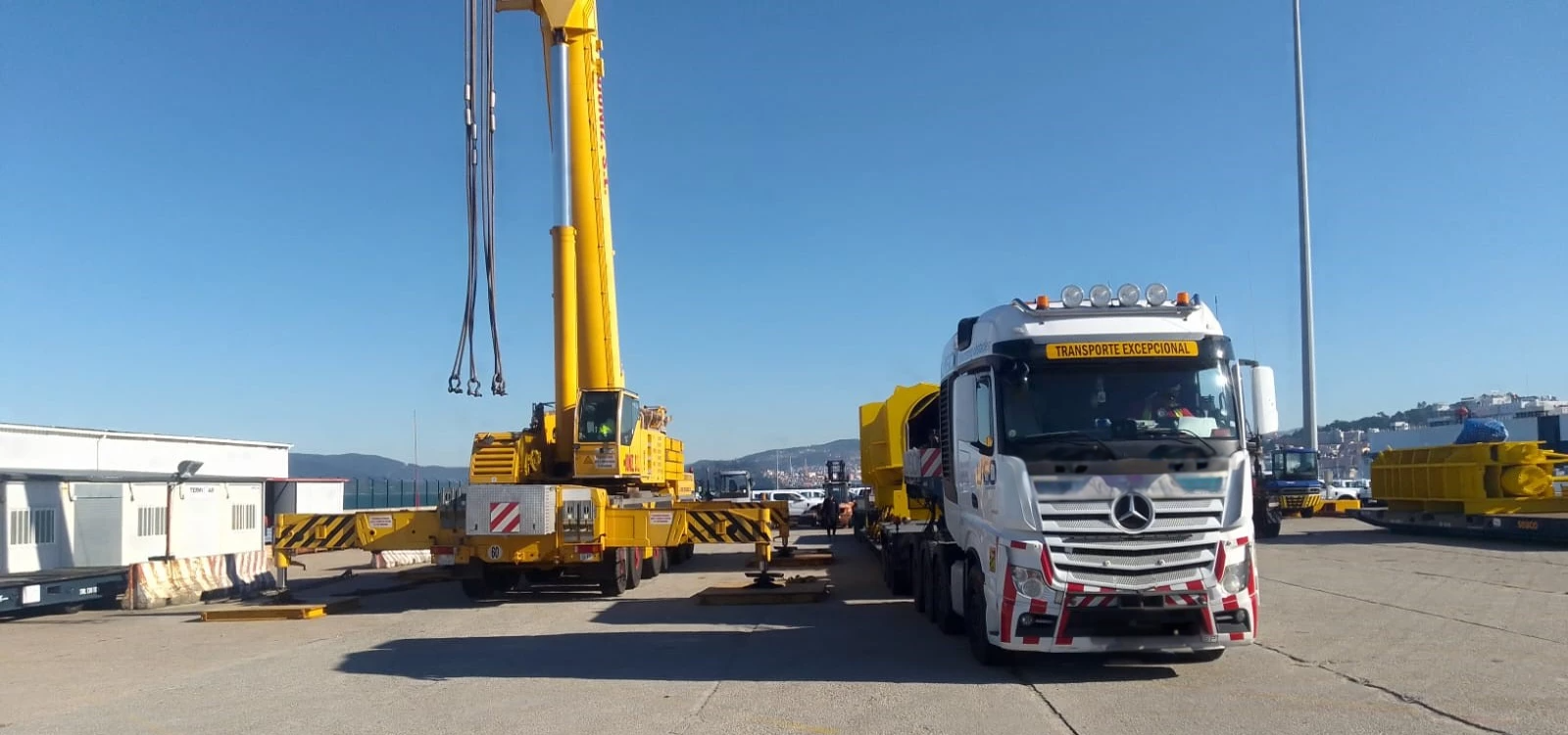 Auf einem Parkplatz steht ein LKW mit einem daran befestigten Kran.