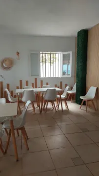Una habitación con mesas y sillas y una ventana.
