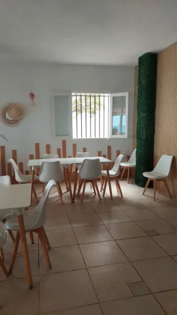 Una habitación con mesas y sillas y una ventana.