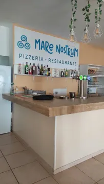 Un restaurante con bar y un cartel en la pared.