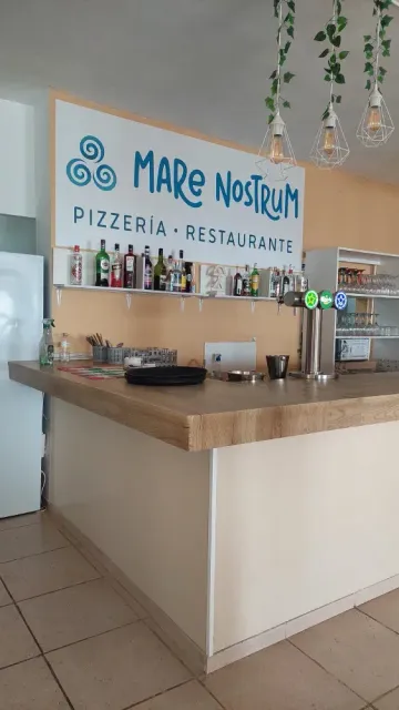 Un restaurante con bar y un cartel en la pared.