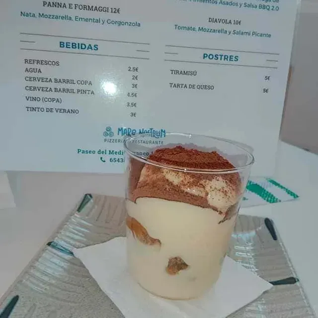 Una taza de comida con un menú en el fondo.
