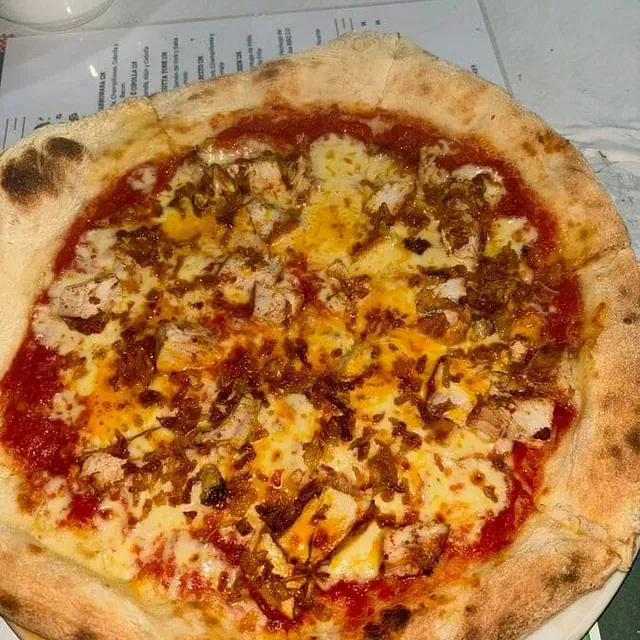 Una pizza con muchos ingredientes encima está en un plato.