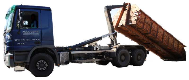 Ein blauer Abrollkipper lädt einen großen Container auf sein Fahrgestell.