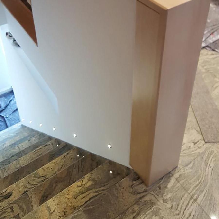 Eine Treppe mit Marmorstufen und einem Holzgeländer