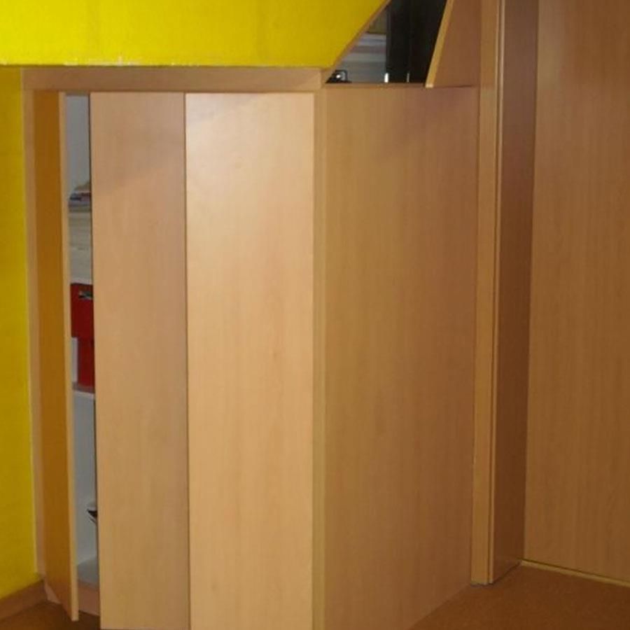 Ein Holzschrank in einem Raum mit einer gelben Wand.