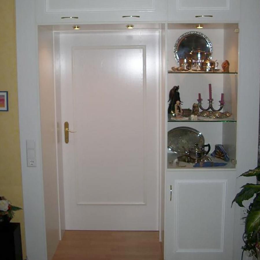 Ein Raum mit einer Tür und einem Regal mit Kerzen darauf