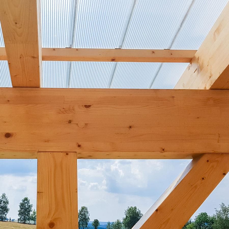Eine Nahaufnahme einer Holzkonstruktion mit einem durchsichtigen Dach