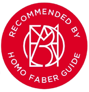 Cercle rouge avec le texte « RECOMMANDÉ PAR LE GUIDE HOMO FABER » et un logo géométrique.