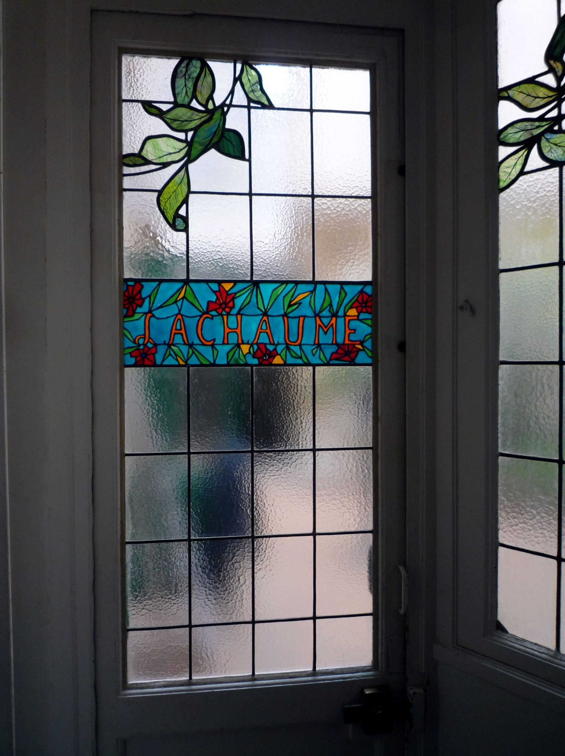 Vitrail orné de feuilles vertes, panneau turquoise portant l'inscription « ACHIEVE » en lettres blanches et motif quadrillé.