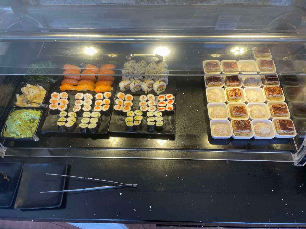 Eine Vitrine mit einer Auswahl an Lebensmitteln, darunter Sushi