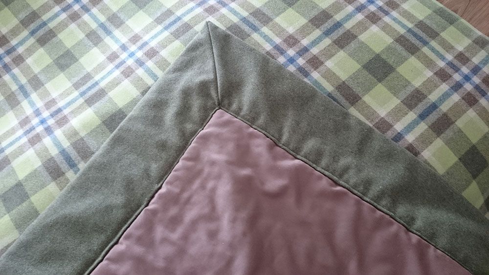 Eine Nahaufnahme einer Decke mit kariertem Rand auf einem Tisch.