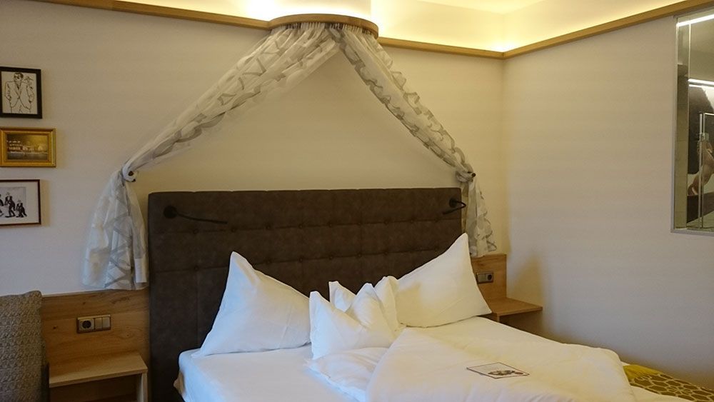 Ein Bett mit einem Baldachin darüber in einem Hotelzimmer.