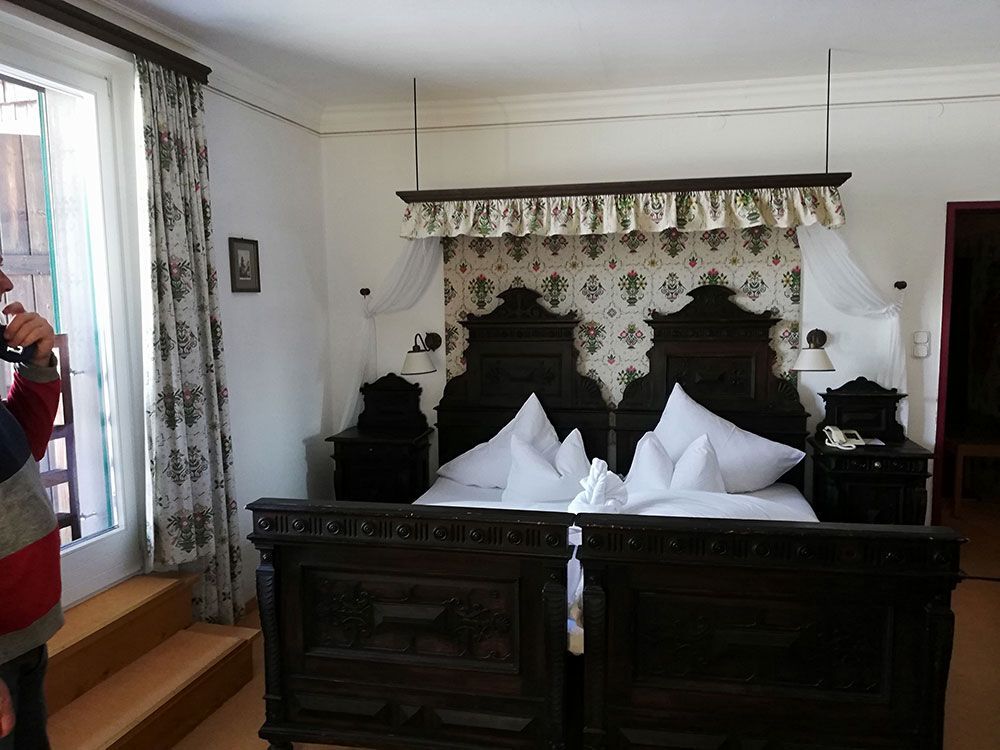 Ein Mann macht ein Foto von einem Bett in einem Schlafzimmer