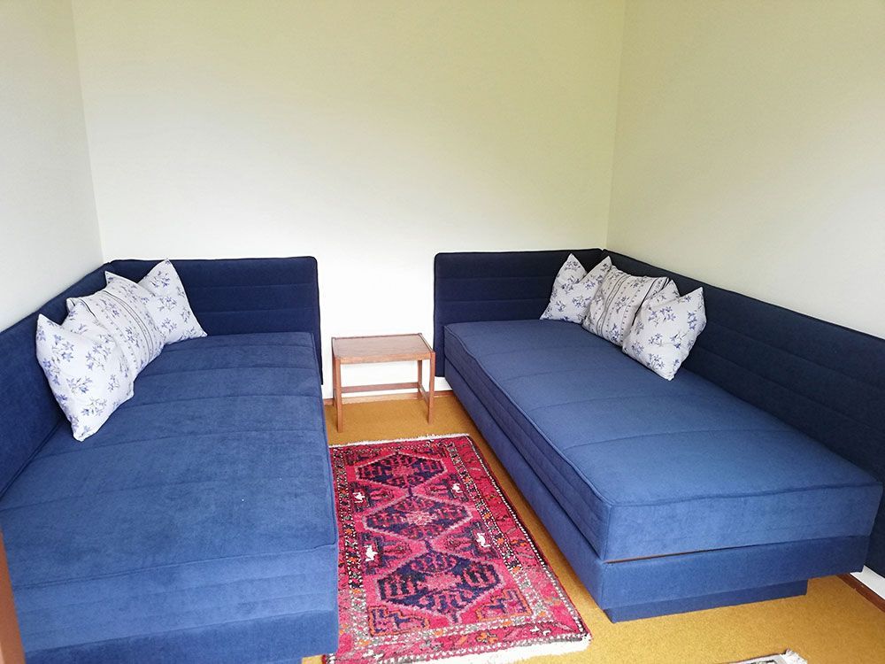 Ein Wohnzimmer mit zwei blauen Sofas und einem Teppich