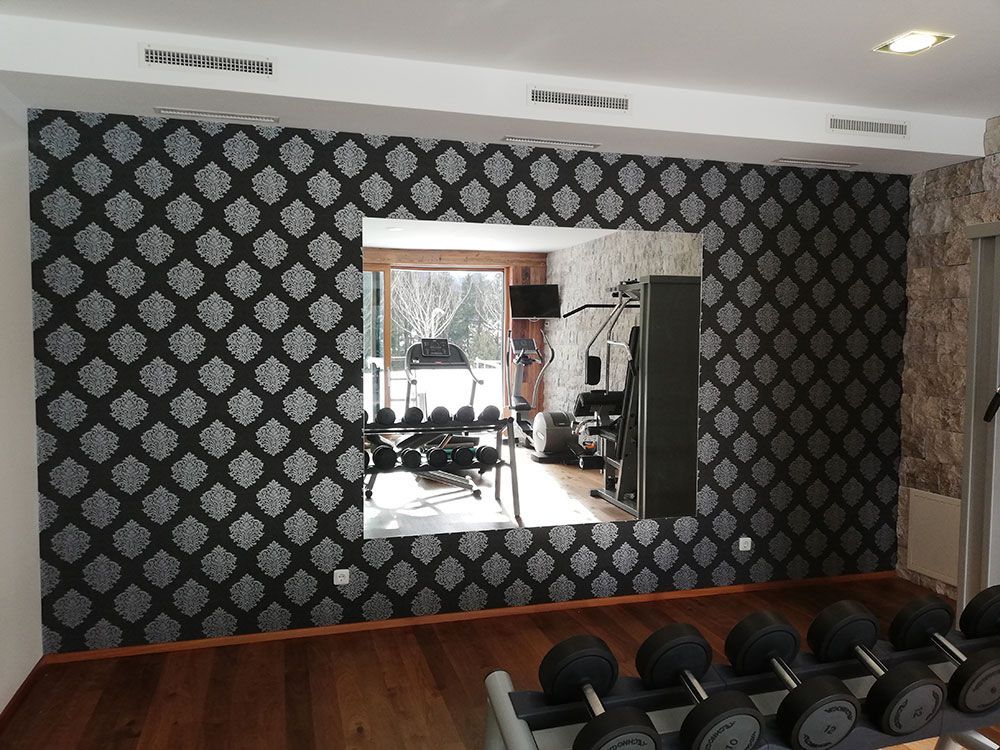 Ein Fitnessstudio mit einem großen Spiegel an der Wand