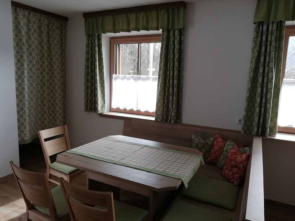 Ein Wohnzimmer mit Tisch und Stühlen und einem Fenster