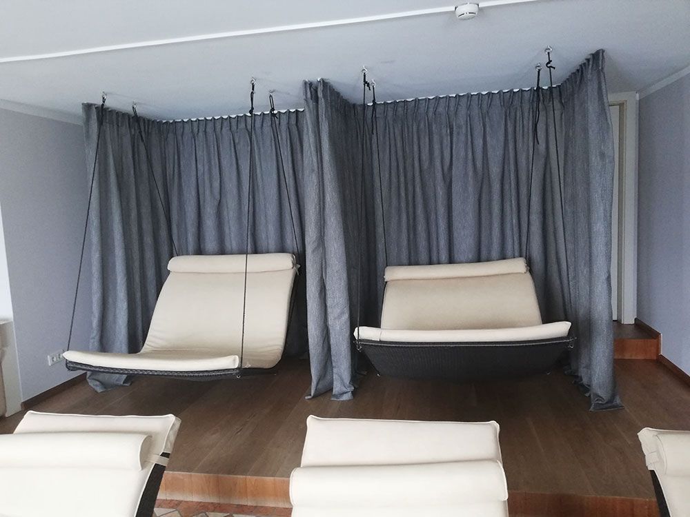 Zwei Stühle in einem Raum mit Vorhängen dazwischen