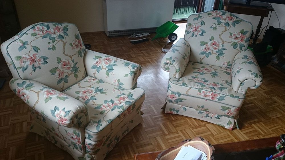 Zwei Stühle stehen auf einem Holzboden in einem Wohnzimmer.