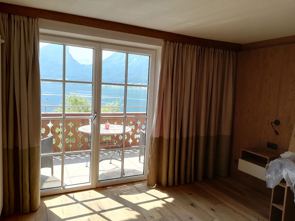 Ein Wohnzimmer mit einer Glasschiebetür, die auf einen Balkon führt.