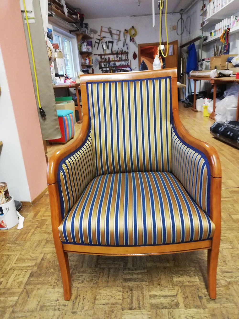 Ein gestreifter Stuhl steht auf einem Holzboden in einem Raum