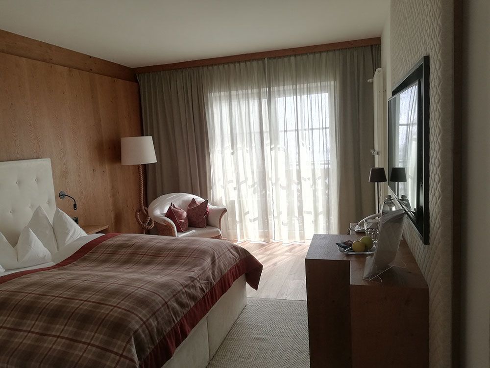 Ein Hotelzimmer mit einem großen Bett und einem Stuhl