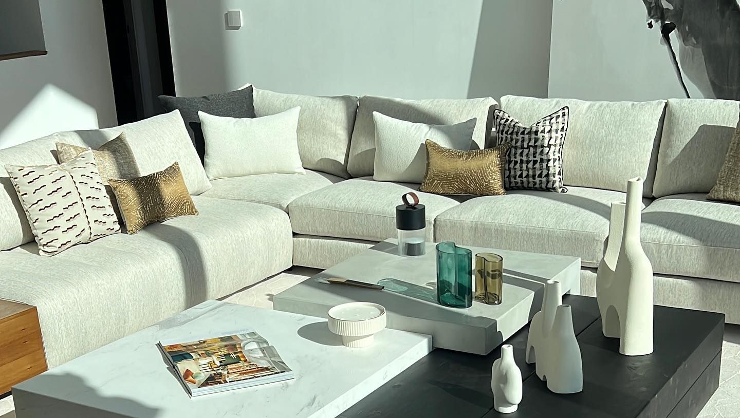 Una sala de estar con un gran sofá seccional y una mesa de café.