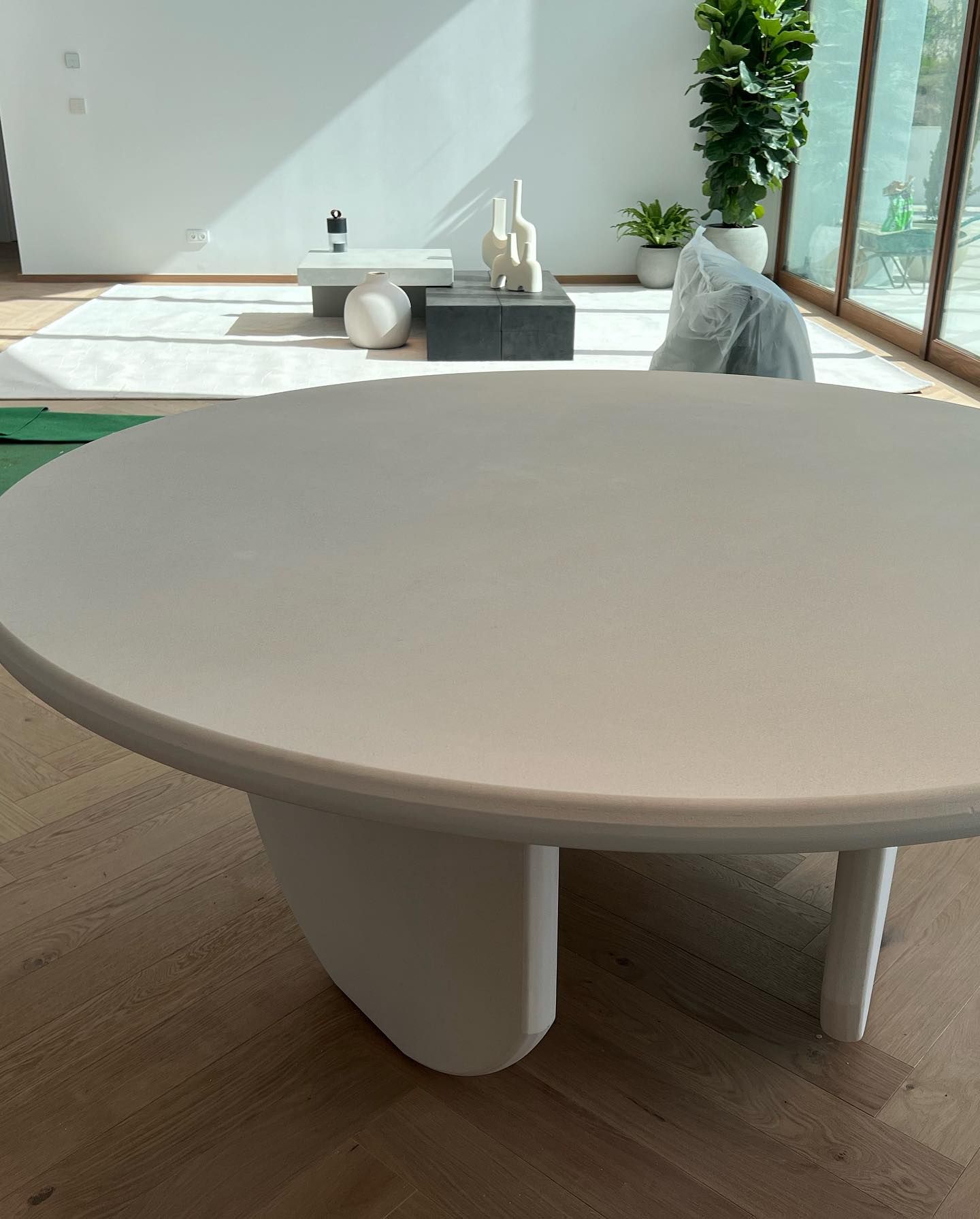 Una mesa blanca en una sala de estar con una planta al fondo.