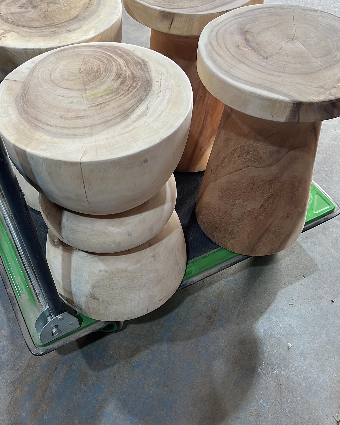 Un grupo de taburetes de madera están apilados uno encima del otro.