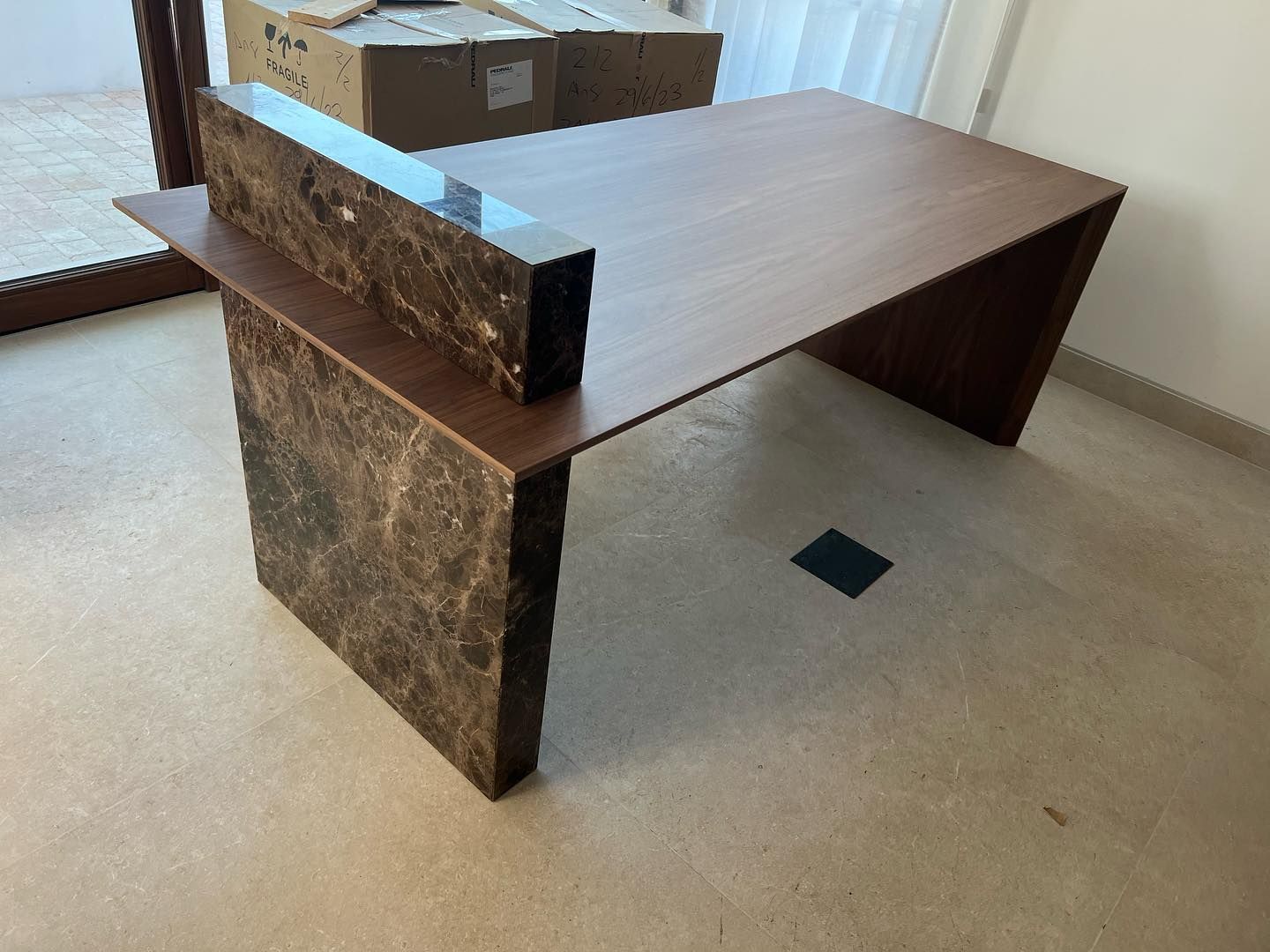 Una mesa de madera con tapa de mármol en una habitación.