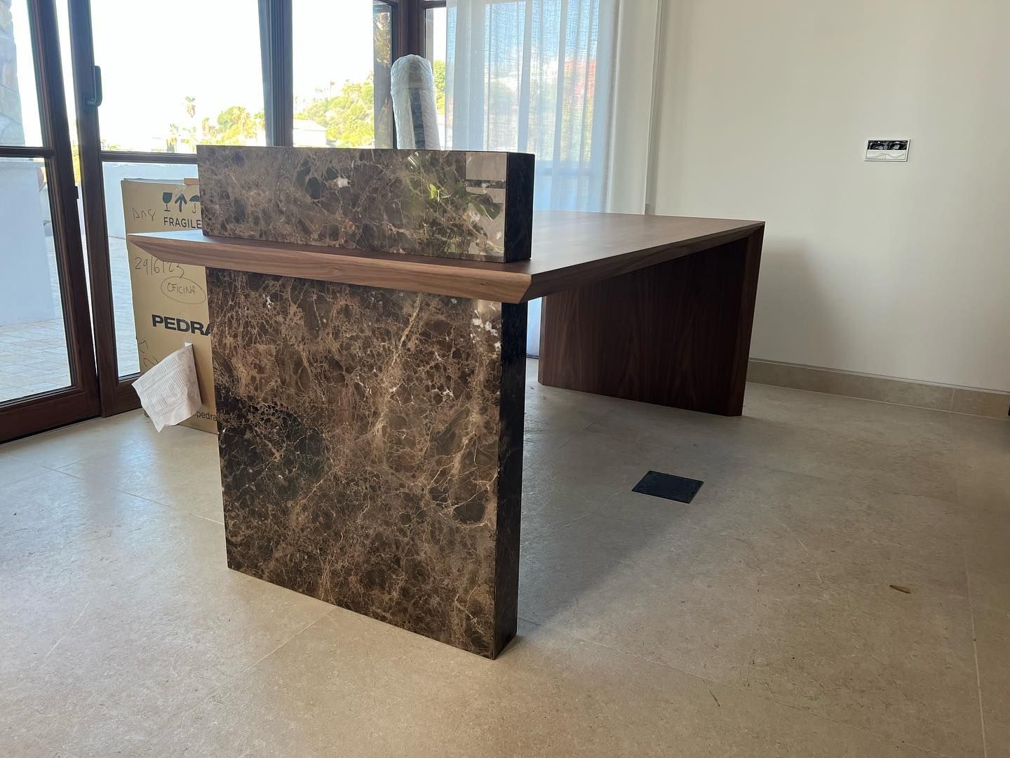 Una encimera de mármol se encuentra en una habitación al lado de una ventana.