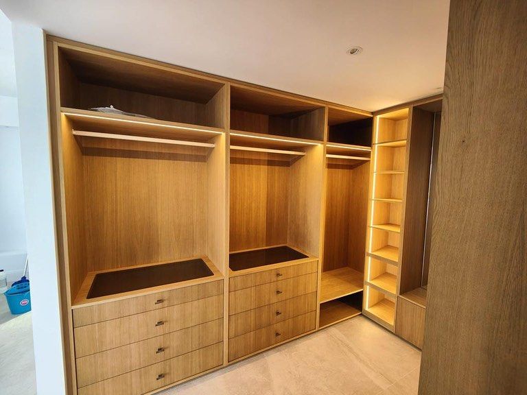 Un vestidor con muchos estantes y cajones de madera.