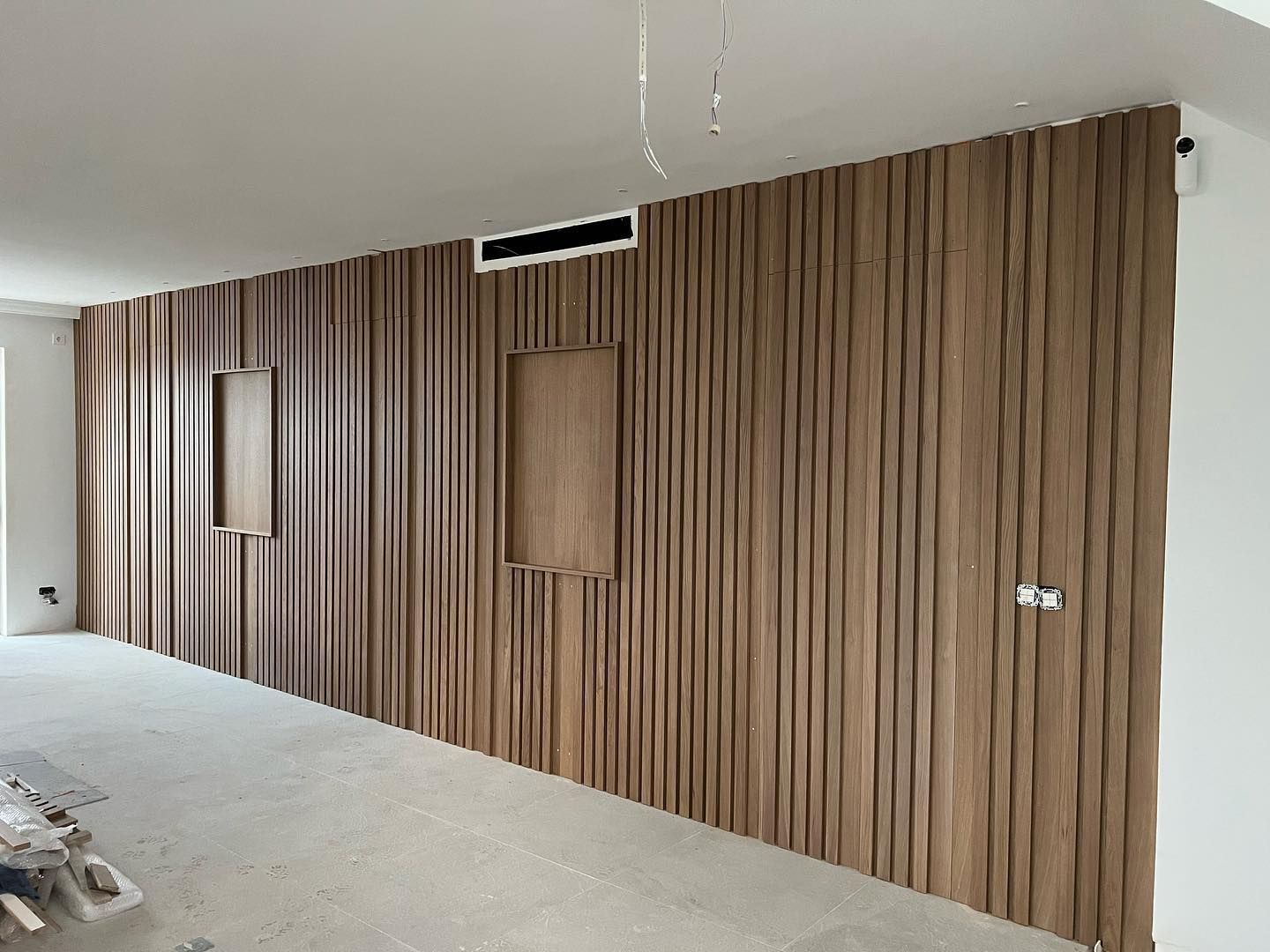 Una sala de estar con una pared de madera y un ventilador de techo.