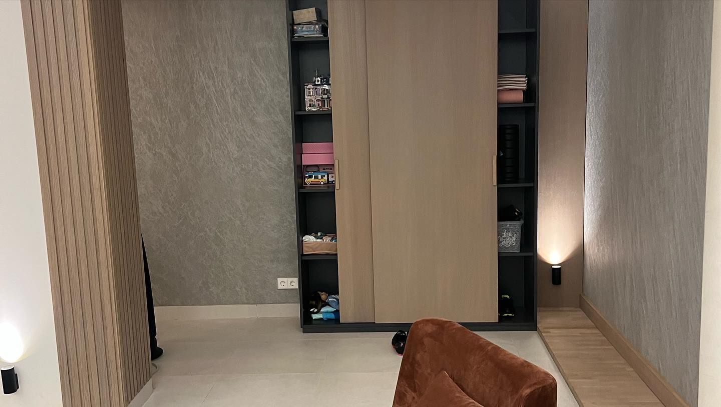 Una sala de estar con un sofá y una estantería.